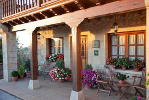 a patio with benches and flowers on a house at Posada San Pedro in Oreña