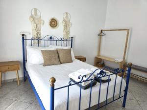 a blue bed with white sheets and a mirror at Fabrika Apartments in Vári