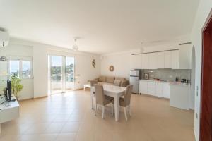 a kitchen and living room with a table and chairs at Villa Er Deti in Sarandë