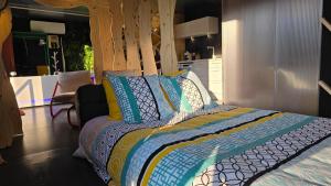ein Schlafzimmer mit einem Bett mit bunten Decken und Kissen in der Unterkunft Maison Triangle in Saint-Alban-dʼAy + 25 Fotos