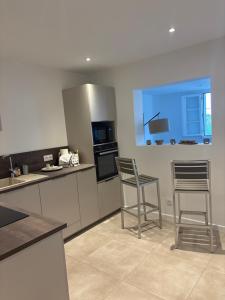 a kitchen with two chairs and a table and a stove at Appartement Bastia Cardo Village in Bastia