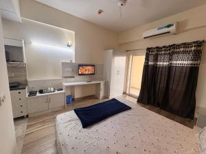 a bedroom with a bed and a desk and a window at Skyline suites in Greater Noida