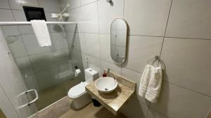 a bathroom with a toilet and a sink and a mirror at Flat em NATAL- RN in Natal