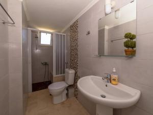a white bathroom with a toilet and a sink at Memi Houses in Koroni +46 photos