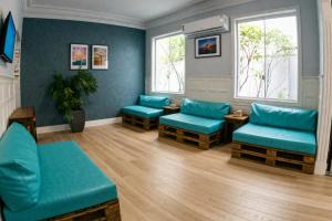 a waiting room with blue chairs and windows at Mango Tree Ipanema in Rio de Janeiro
