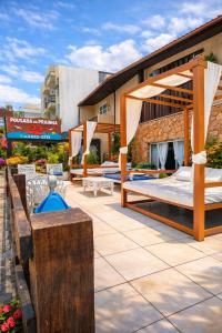 a patio with two beds and a building at Pousada da Prainha in Arraial do Cabo