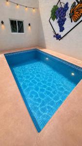 a swimming pool in a house with a blue pool at Stellarium Hotel-Valle de Guadalupe in Francisco Zarco