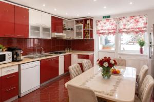 a kitchen with a table with a vase of flowers on it at Pensiunea Alex in Borsa