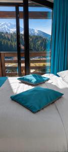 a bed with two pillows on it in front of a window at Pensiunea Alex in Borsa +22 photos