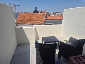 a balcony with a table and chairs on a building at L'Escale Sablaise in Les Sables-d'Olonne