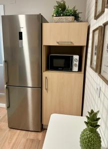 a stainless steel refrigerator with a microwave in a kitchen at Alegría 2 in Amés