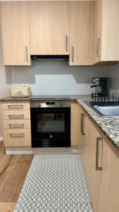 a kitchen with a black oven and a sink at Alegría 2 in Amés +11 photos
