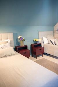 a bedroom with two beds and two tables with flowers on them at Flowland Tarczyn in Tarczyn