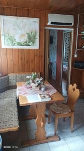 a wooden table with flowers on it in a room at Fa-mìlia Vendègház in Tiszavasvári