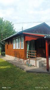 a small wooden house with a fence in front of it at Fa-mìlia Vendègház in Tiszavasvári