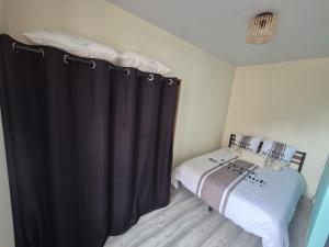 a bedroom with a black curtain next to a bed at L'Escale Sablaise in Les Sables-d'Olonne