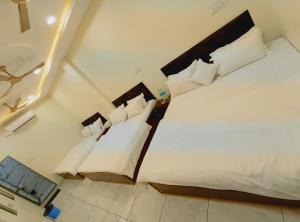 a bedroom with a bed with white sheets and pillows at The Comfort Villa in Ujjain +27 photos