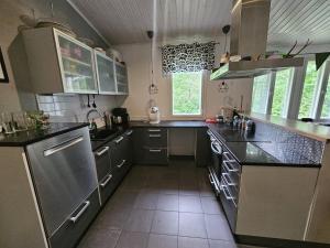 a large kitchen with stainless steel appliances and counters at Villa Herttala in Jyväskylä