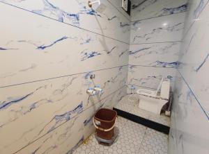 a bathroom with blue and white marble walls and a toilet at The Comfort Villa in Ujjain