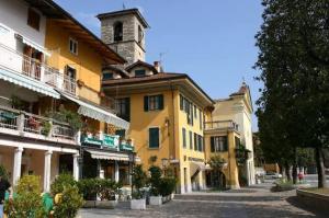 a yellow building with a clock tower on a street at Casa Renoir appartamento a due passi dal lago in Verbania