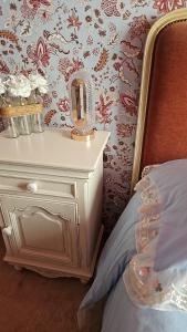 a bedroom with a bed and a nightstand with a mirror at Chambre d'hôtes Le Havre in Saint-Coulomb