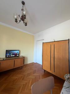 a living room with a television and a wooden cabinet at Studio Apartmani ISRA in Palit