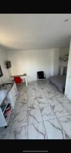 a room with a marble floor with a bed and a desk at Studio dans une villa in Perpignan