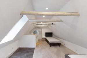 a white attic room with a bed and a table at Naturparadies an der Saale in Könnern
