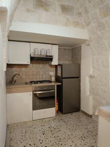 a kitchen with a refrigerator and a stove top oven at Trullo Le Tre Sorelle in Cisternino