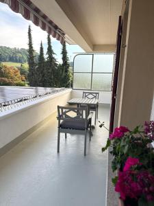 a balcony with two chairs and a table and a window at Helle Wohnung nahe Bern in Worb