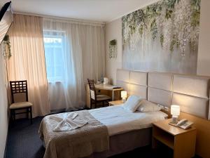 a hotel room with a bed and a desk at Great Polonia Silesian Economy Hotel in Katowice