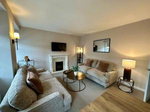 a living room with two couches and a fireplace at Stay 55 in Peebles