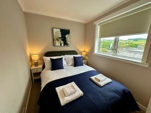 a bedroom with a large bed with a window at Stay 55 in Peebles +14 photos