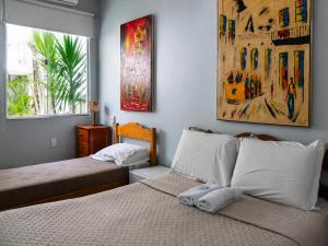 a bedroom with two beds and a painting on the wall at Mango Tree Ipanema in Rio de Janeiro