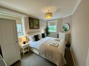 a bedroom with a bed and two windows at Stay 55 in Peebles