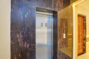 a shower with a glass door in a bathroom at Hotel O by OYO S R Galaxy in Kānpur