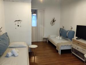 a small room with two beds and a tv at Sofia’s in Livadi