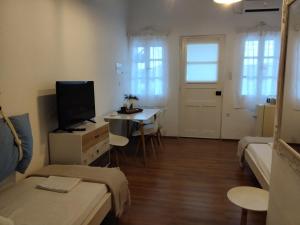 a living room with a bed and a table with a tv at Sofia’s in Livadi