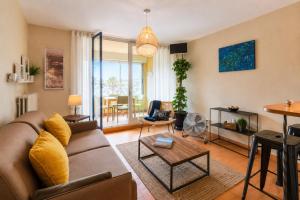 a living room with a couch and a table at TERRASSE Vue MARINA - PARKING Privé - Port Commerces & PLAGE à PIED - Vue Exceptionnelle - RétroMirabeau "Côté Mer" in Gruissan