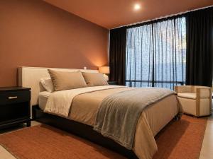 a bedroom with a large bed and a large window at Casa DUALIA in San Miguel de Allende
