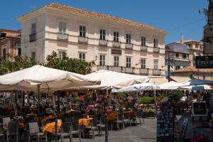 a group of people sitting at tables under umbrellas at Hotel della Piazza in Pizzo