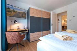 a bedroom with a desk and a bed and a chair at Haffhafen in Garz