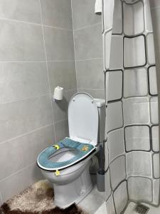 a bathroom with a toilet with a blue seat at Kutbi Guest House in Bokonbayevo +45 photos