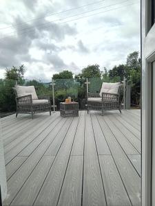 two benches sitting on top of a wooden deck at Five Valleys, Ballinastraw in Bunclody
