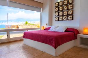 a bedroom with a bed and a large window at Villa MAJUM Acapulco in Acapulco +109 photos