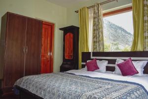 a bedroom with a large bed with pink pillows at Samoon Guest House Sonmarg in Kulan