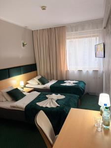 a hotel room with two beds and a table at Great Polonia Silesian Economy Hotel in Katowice +63 photos