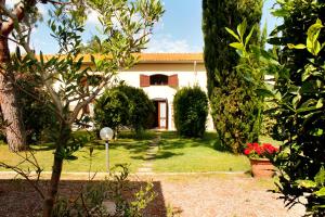a garden with a house in the background at Appartamenti Il Granaio in Marina di Grosseto