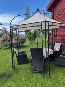 a gazebo with a table and chairs under it at Gillestugan in Rättvik