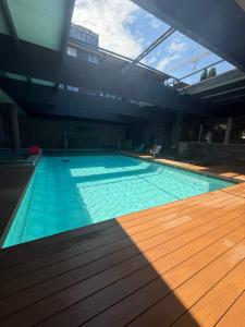 a large swimming pool with a wooden floor at Cors'Hotel in Biguglia